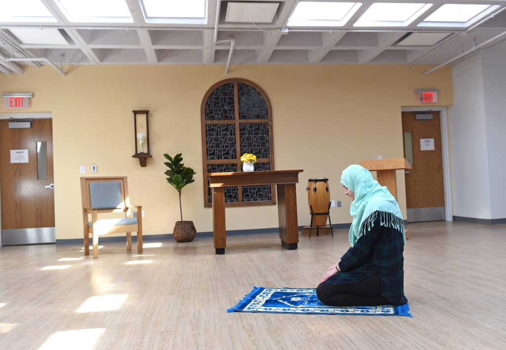 Interfaith Chapel space being used for daily prayers. Showing a muslim student facing mecca.