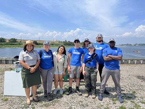 A group photo of Shorebird Ecology Ambassadors at the Jamaica Bay Wildlife Refuge, with Joseph Benevento at center. A National Park Service ranger is also in the photo.